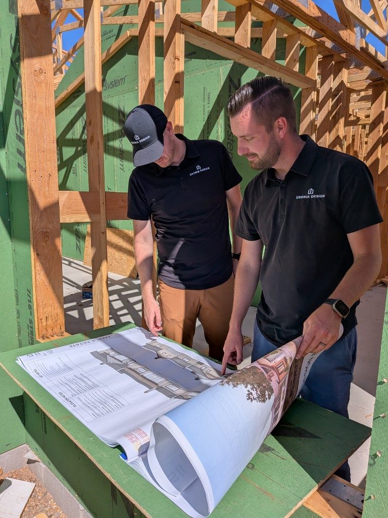 Chase and Jackson Beazer reviewing architectural plans on a Prescott job site